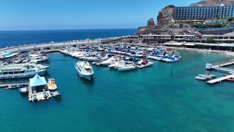 Drone Over Small Port with Turquoise Water and Tourist Boats, Clear Sky Stock Footage 310142640