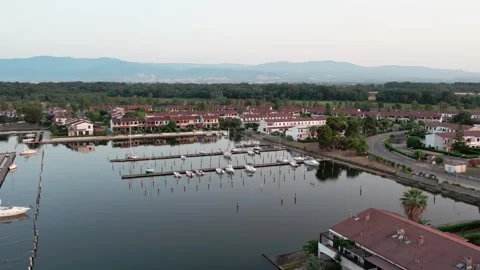 A drone over a small town on a lake. Marinas, Cloudy summer sunset. Sibari Stock Footage 311709050