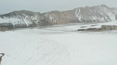 Drone Over Snow Covered Mountains With Braided River Below Stock-Footage 168774337