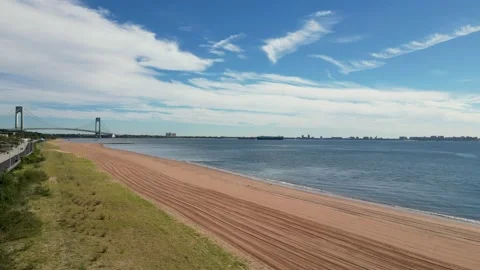 Drone over Staten Islnad beach looking at the Verrazano Narrows Bridge Stock Footage 230918049