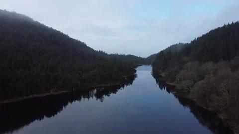 Drone over a still lake in a calm valley on the water surface Video stock 335199376