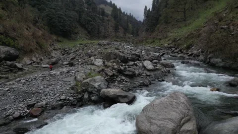 Drone Over Valley River with Man Walking Among Rocky Terrain Video stock 313382484