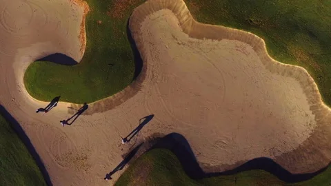 Drone overhead of groundskeepers blowing leaves and rake sand trap on golf co Stock Footage 167143338