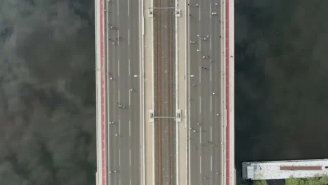 Drone overhead view of runners crossing a bridge in a marathon. Video stock 158270707