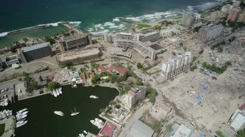 Drone overview reveals a devastated urban shoreline with relief camp tents Stock Footage 340905049