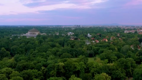 Drone pan above dense forest canopy revealing historic domed landmark building Stock Footage 312593105