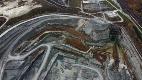 Drone pan above open mining pit with factory towards large lake Stock Footage 251260586