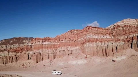 Drone pan of arid red ridge with a tourist bus Stock Footage 91463019