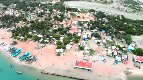 Drone pan down over fishing boats in a paradise fishing village. Stock Footage 140250092