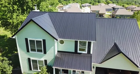 Drone Pan Down Towards Black Metal Roof on Green House Stock Footage 201576126