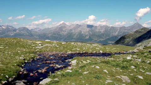 Drone pan over Pian Cavalli mountain stream in the Italian Alps near Madesimo Видео 319170853