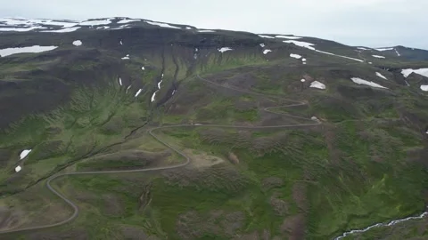 Drone pan revealing serpentine mountain pass road, Hellisheidi Eystri Stock Footage 346552114