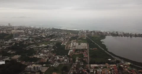 Drone pan shot of Macaé cityscape with ocean and Imboassica Lagoon Stock Footage 317731121