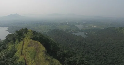 Drone pan shot of mountain ranges and lush green forests Stock Footage 117581026