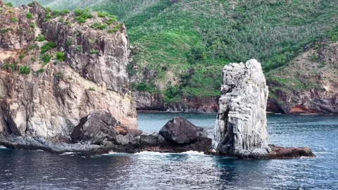 Drone pan shot of rugged cliffs and rocks over the ocean Stock Footage 308517931