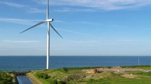 Drone panning around big windmill and excavator working at a junkyard Stock Footage 314213578