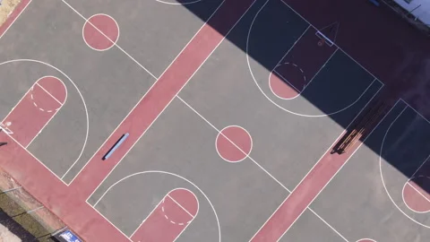 Drone panning away from basketball court while rotating Stock Footage
