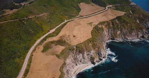 Drone panning left over amazing Highway 1 and beautiful Pacific Ocean sunny Stock Footage 102652228