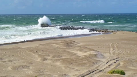 Drone panning over beach where big waves hitting a pier at the North Sea in.. Stock Footage 335993081
