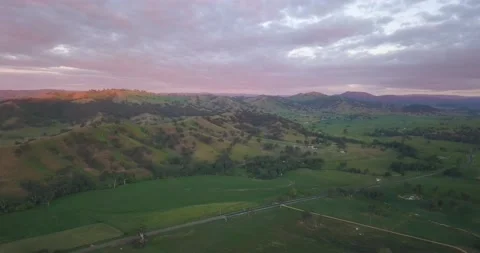 Drone panning to show green rolling hills and red cloudy sky, Australia Stock Footage 134617920