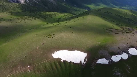 Drone panorama of green rolling hills and isolated snow patches in Kazakhstan Stock Footage 337140528