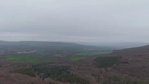 Drone panorama of rolling hills, cloudy sky and distant green valleys Stock Footage 323320852