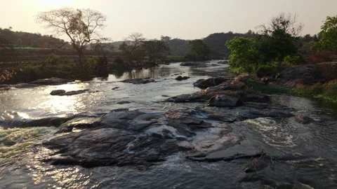 Drone Panoramic shot over a river flowing next to fields in rural India Stock Footage 305260141