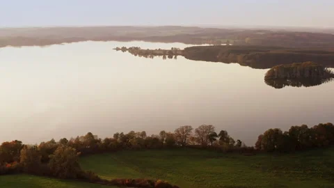 A drone pans over a lake with a small island with trees. Location: Germany 스톡 동영상 239102910