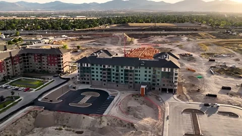 Drone parallax orbit ascent above apartment complex construction in Stock Footage 340564892