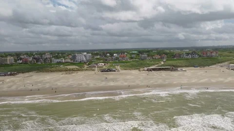 Drone parallax pullback along Noordwijk Beach and North Sea coastline, South Stock-Footage 342180588