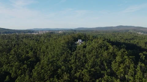 Drone parallax pullback revealing hilltop sanctuary above the forests of Видео 341901839