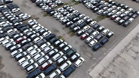 Drone parallax push-in with tilt down above large automotive vehicle storage Vidéo 340763062