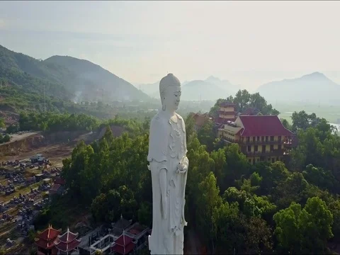 Drone Passes Large White Buddha Statue and Moves to Temple Stock Footage 75596170