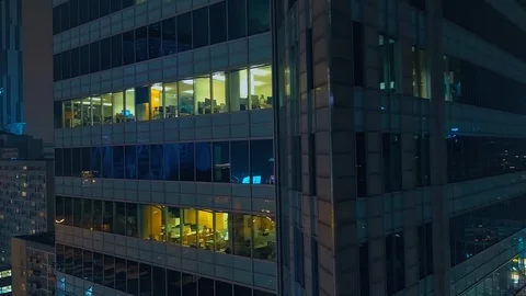 The drone passes by a modern, glazed skyscraper and we can see offices closely. Stock Footage 108570384