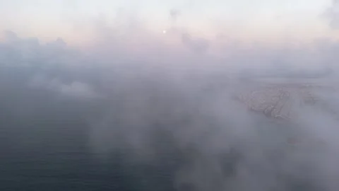A drone passes through clouds over the ocean at sunrise, capturing the gold.. Stock Footage 287135081