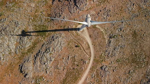Drone passing above wind turbine and mountain road Stock Footage 341434526