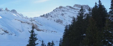 Drone passing pine trees closely. Snow covered mountain slopes. ski lift. Aerial Stock Footage 121483869