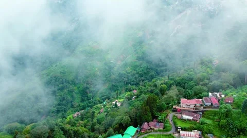 Drone Passing Through Clouds Over Mountain Town With Green Valley Views Stock Footage 321994287