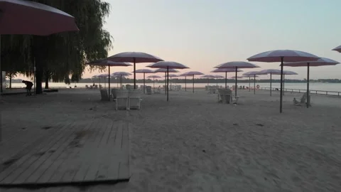 Drone passing through umbrellas at beach Stock Footage 143109792