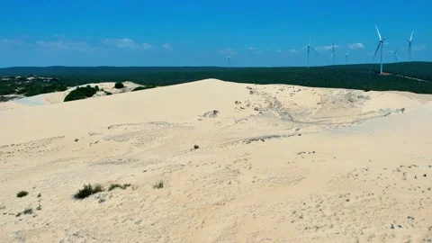 Drone pedestal reveal of a massive wind turbine farm over sand dunes 4K Stock Footage 338370167
