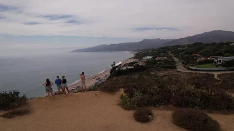 Drone - People looking at ocean from a cliff Stock Footage 250281293