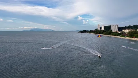 Drone perspective captures parasailing at Batu Ferringhi with radiant parachutes Vídeos de archivo 332091623