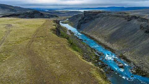 Drone perspective of deep basalt canyon carved by bright turquoise glacial ri Stock Photos