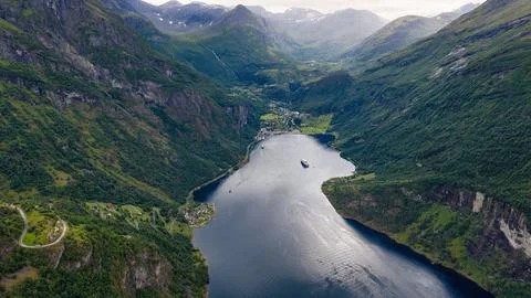 Drone perspective of deep fjord with anchored vessels, surrounded by vertical Stock-Fotos
