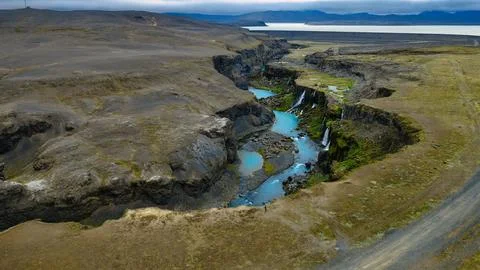 Drone perspective of a deep lava canyon featuring milky turquoise glacial wat Stock Photos