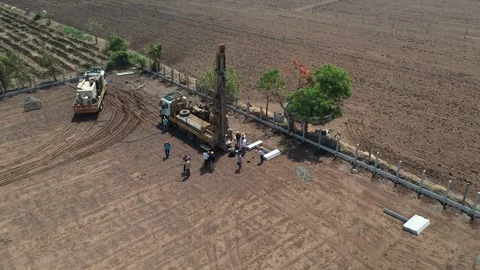 Drone perspective looking down at a mobile water truck and a heavy drilling rig Stock Footage 337194292