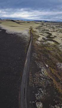 Drone perspective of Route 1 traversing black volcanic terrain and tan sand p Stock-Fotos