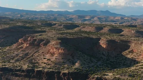 Drone Perspective of Rugged Southwest Mesa Formations with Sunlit Mountains and Stockbeeldmateriaal 333440466