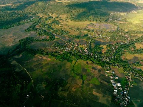 Drone perspective of settlement beneath forested highlands Stock Photos
