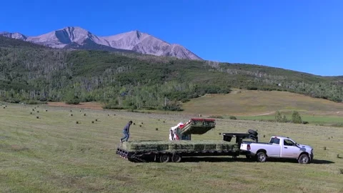 Drone:  Picking Up Hay Bales on Mountain Ranch Stock Footage 206191597
